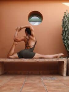 Woman in yoga pose on bench outdoors