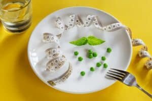 A white plate topped with peas and measuring tape